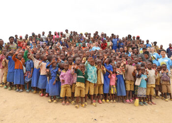 Thornton Tomasetti team members pose with local schoolchildren while visiting Nyagisumo, Rwanda, to construct a footbridge with Bridges to Prosperity.