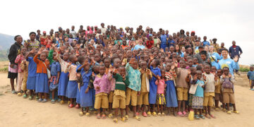 Thornton Tomasetti team members pose with local schoolchildren while visiting Nyagisumo, Rwanda, to construct a footbridge with Bridges to Prosperity.